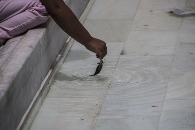 Midsection of girl dipping feather in water