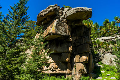 Low angle view of sculpture on rock against sky