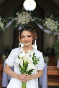 The bride with braces teeth and flower in hand with flower