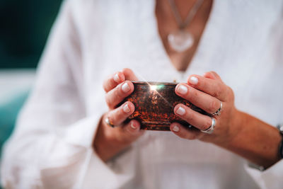 Hands of a emotionally aware person, kindly offering contents of an energized copper bowl