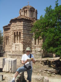 Man reading book against church of the holy apostles