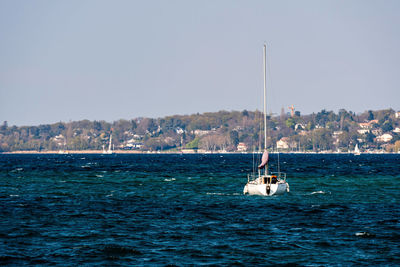 Sailboat sailing on sea against clear sky