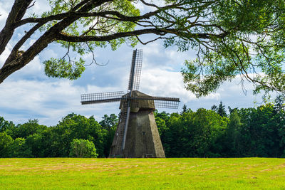 Traditional windmill on field against sky