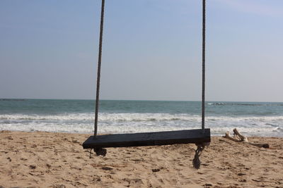 Close-up of swing at beach against clear sky