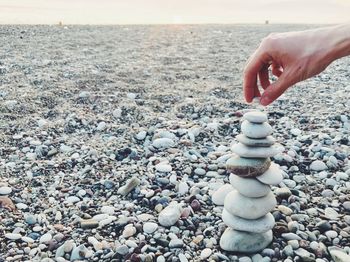 Person hand on pebbles at beach