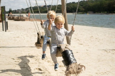 Cute boys swinging on beach