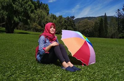 Portrait of happy girl on grass against sky