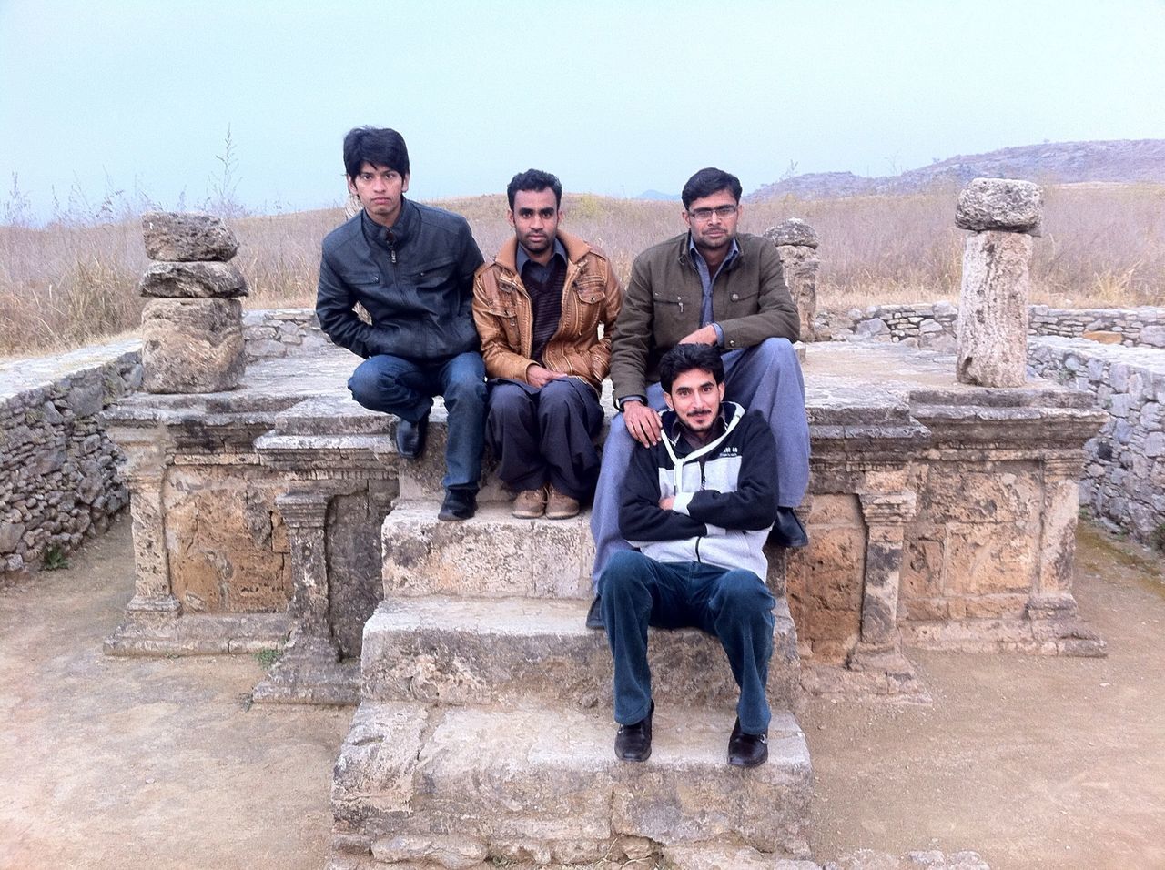 lifestyles, leisure activity, casual clothing, full length, young adult, young men, person, togetherness, built structure, architecture, bonding, building exterior, history, standing, old ruin, smiling