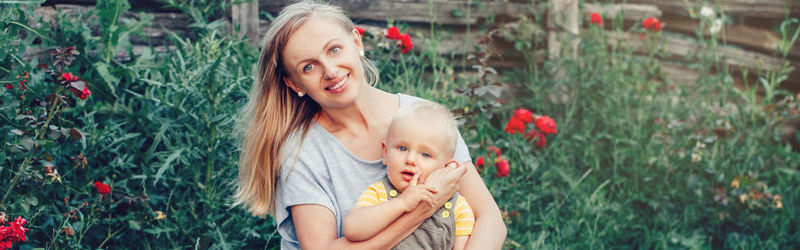 Portrait of smiling woman with red flower