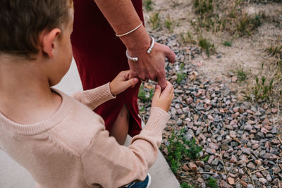 Above view of young boy holding moms hand outside