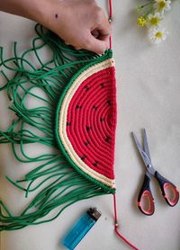 Cropped hand of woman knitting at home