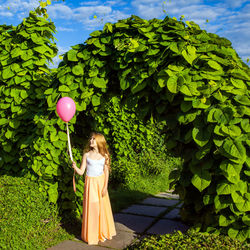 Woman standing with balloons and leaves