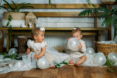 Cute girls playing with balloons at home