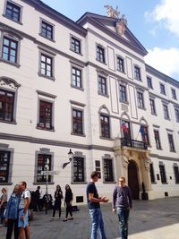 People standing against sky in city