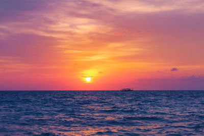 Scenic view of sea against romantic sky at sunset