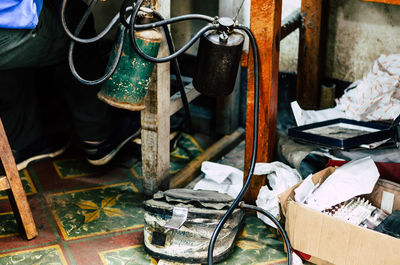 Low section of man sitting by equipment on table