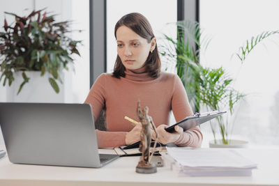 Young woman using laptop at office
