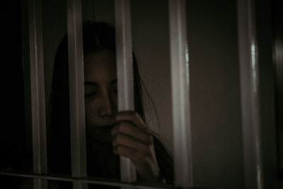 Portrait of woman looking through window