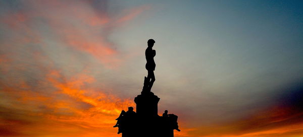 Low angle view of silhouette statue against sky during sunset