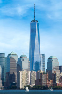 Skyscrapers in city against cloudy sky