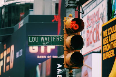 Close-up of road sign against buildings in city