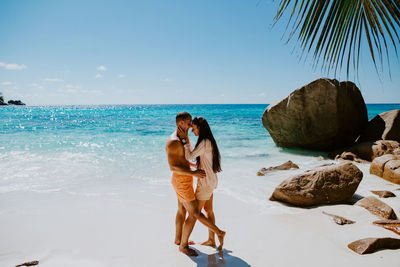 Side view of smiling couple romancing at beach