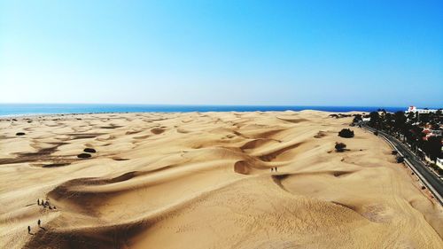 Scenic view of beach against clear blue sky