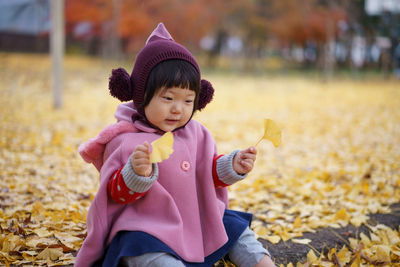 Close-up of cute girl in autumn leaves