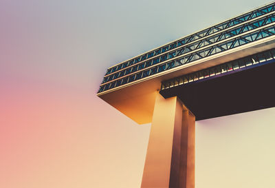 Low angle view of skyscraper against sky during sunset