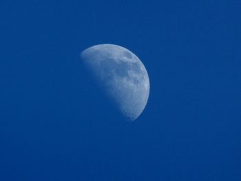 Low angle view of moon against blue sky