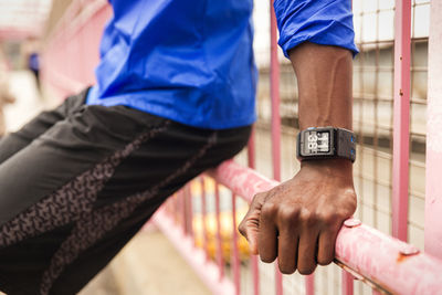 Midsection of man leaning on fence