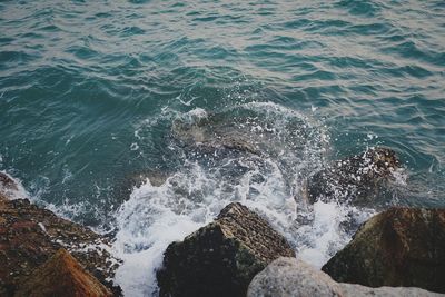 High angle view of waves splashing on rocks