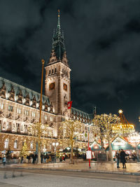 Hamburg townhall during the christmas time. the christmas market can be seen in the background.