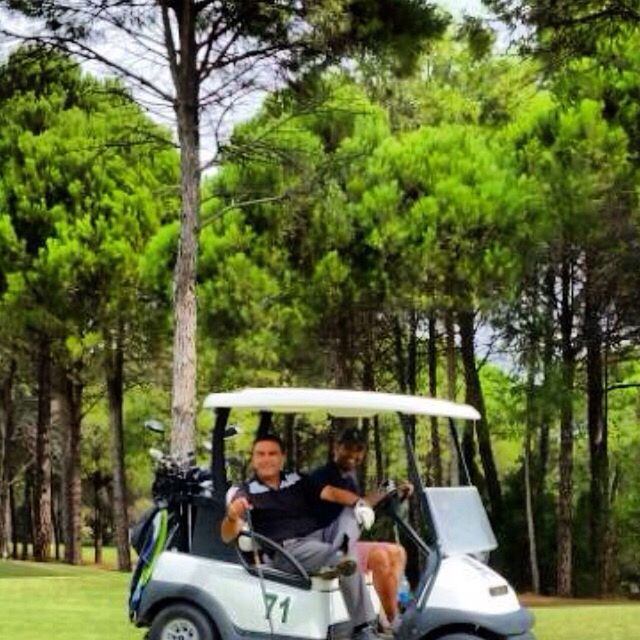 tree, lifestyles, leisure activity, transportation, mode of transport, sitting, men, land vehicle, travel, relaxation, casual clothing, young adult, green color, car, person, togetherness, day