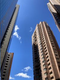 Low angle view of modern buildings against blue sky