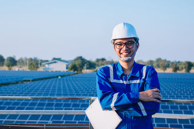 Portrait of smiling man standing against blue sky