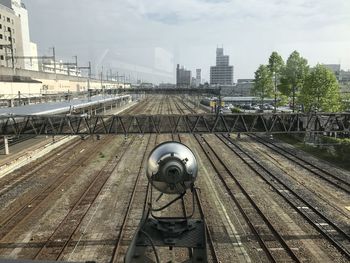 Railroad tracks against sky in city