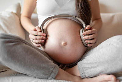 Midsection of woman lying on bed