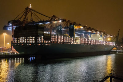 Illuminated bridge over river at night