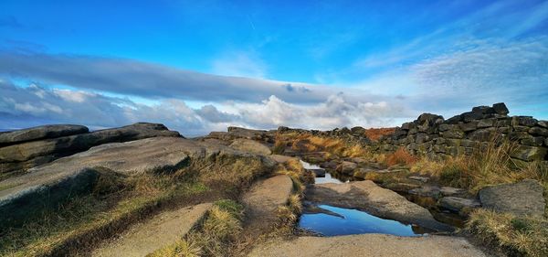 Panoramic shot of rocks on land against blue sky