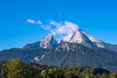 Scenic view of snowcapped mountains against blue sky