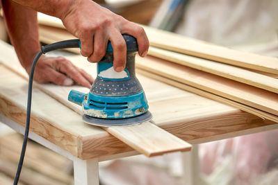 Cropped hands of carpenter working in workshop