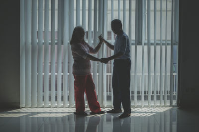 Rear view of couple standing against wall