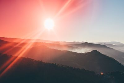 Scenic view of mountains against bright sun