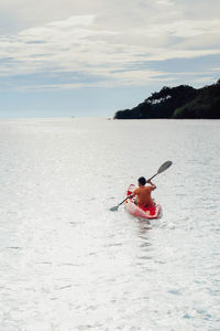 Man surfing in sea against sky