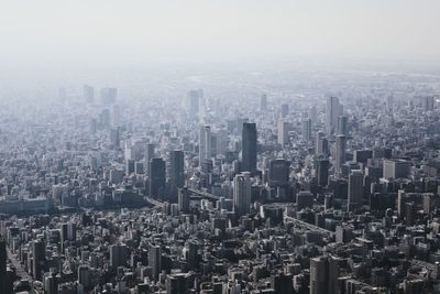 Aerial view of buildings in city against sky