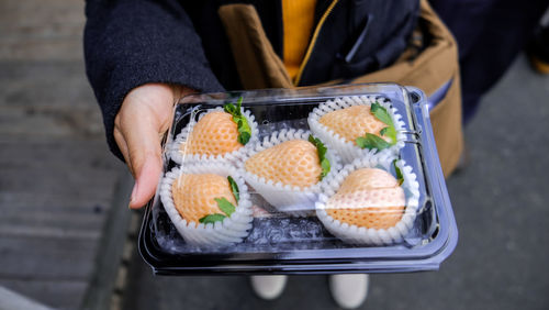 Midsection of person holding strawberry 