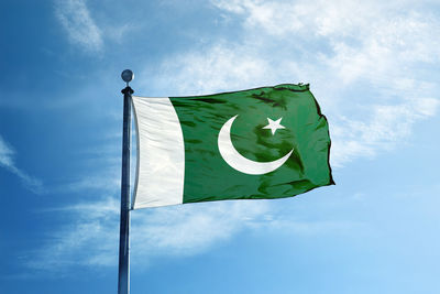 Low angle view of flag against blue sky