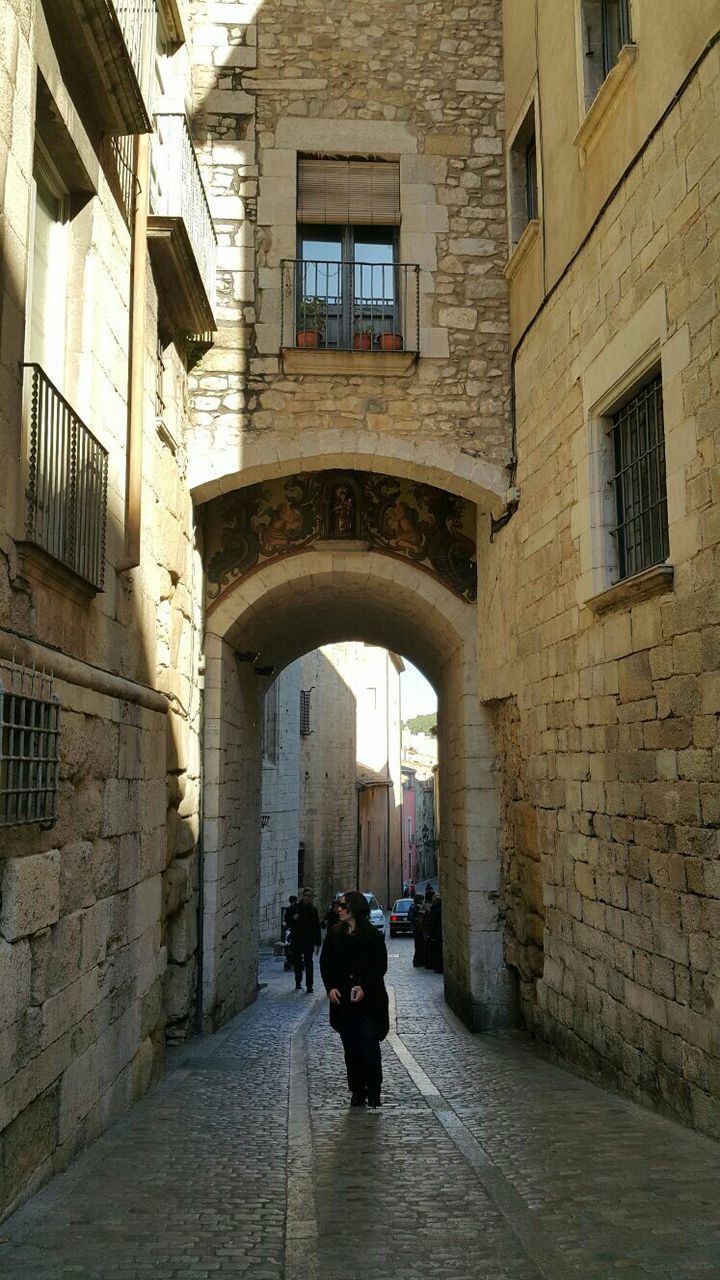 architecture, built structure, building exterior, men, walking, the way forward, arch, street, lifestyles, building, full length, cobblestone, person, alley, window, rear view, residential building