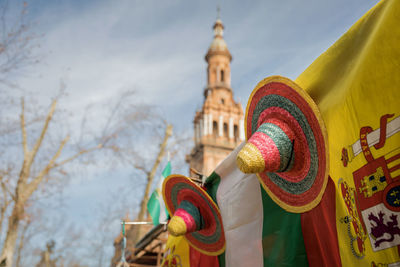 Low angle view of colorful hats hanging on flags in city